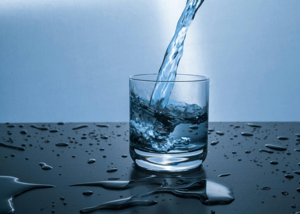 clean glass of drinking water being poured into a cup