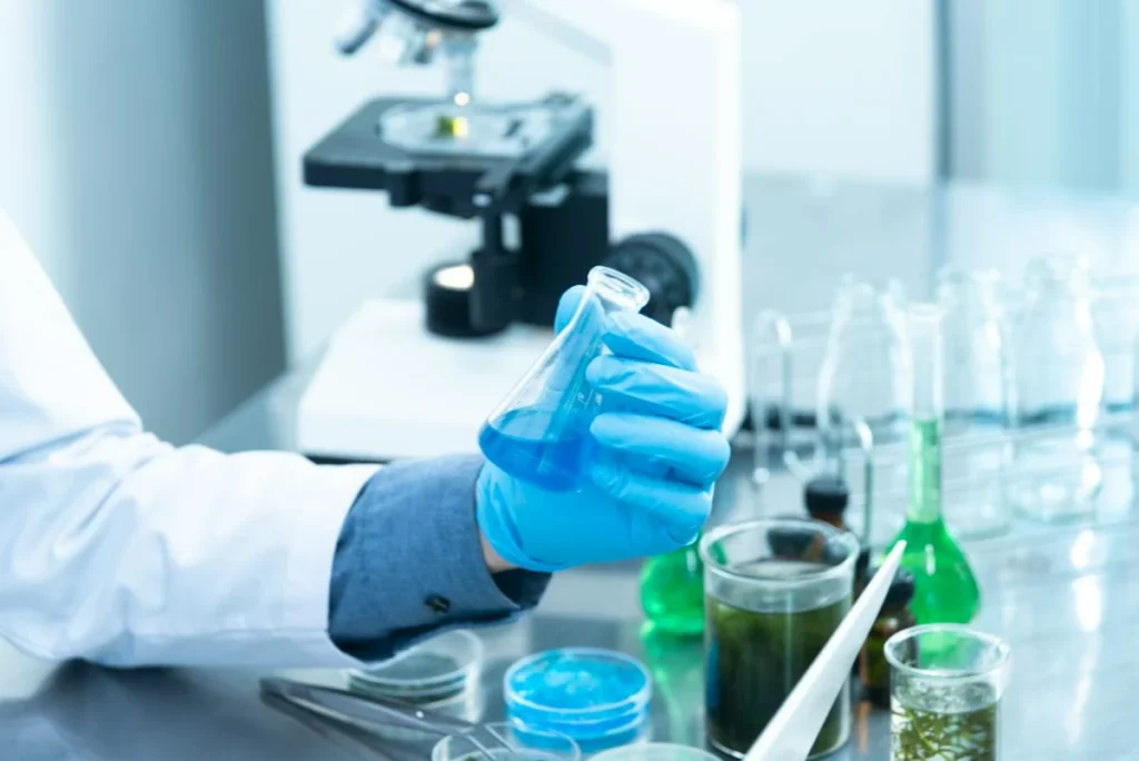 Scientist staring at test tube testing water. 